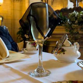high tea mini sandwiches and scones, along with straw hat in the lobby of Biltmore Hotel, DTLA; floral pattern China, fountain in the background, sugar cubes to sweeten hibiscus tea