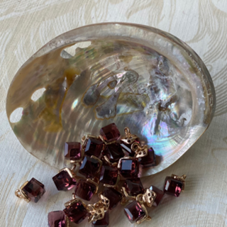 abalone shell displaying sparkling glass cube beads in the shade of merlot 